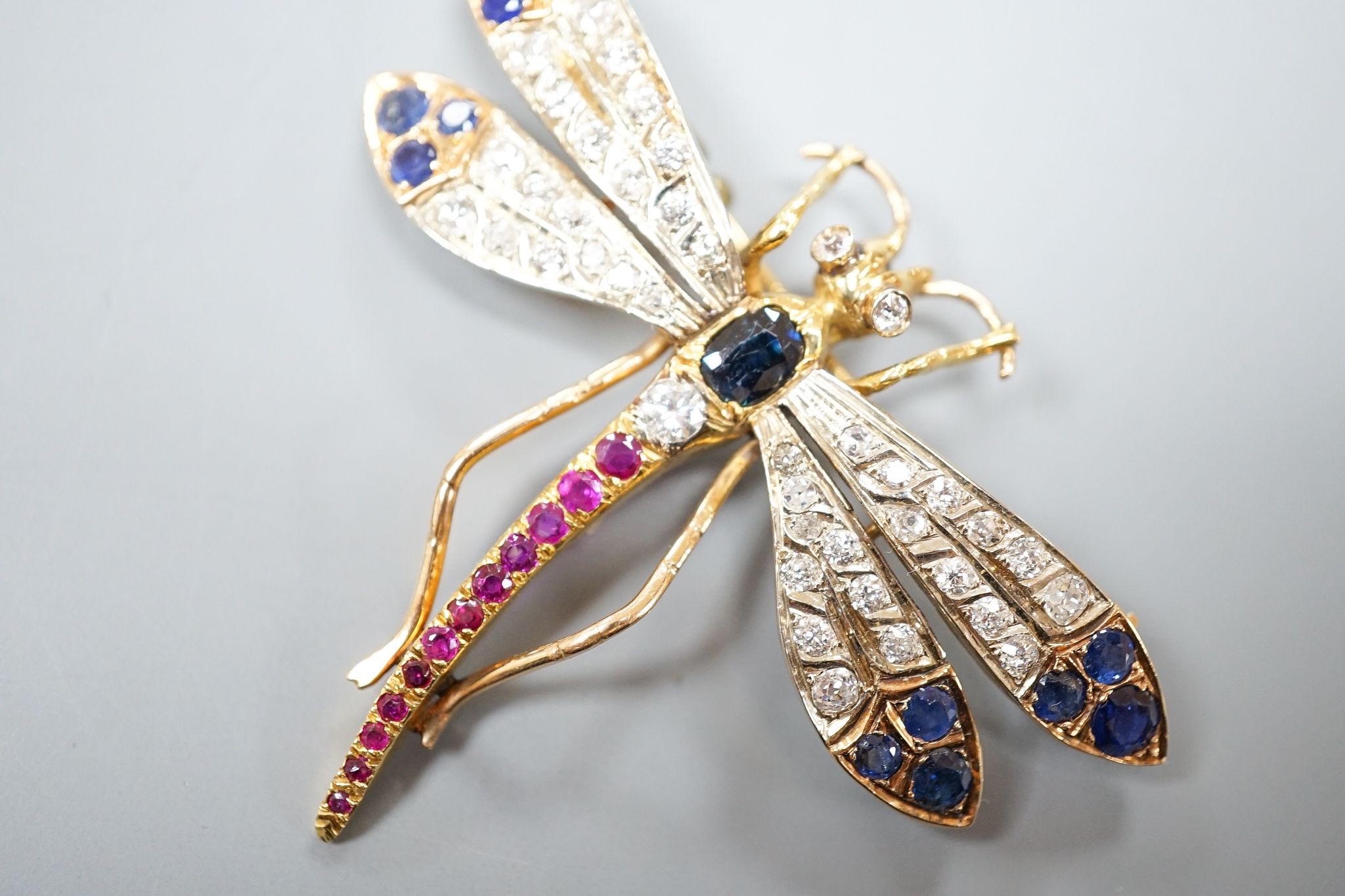 A Victorian style 14k, ruby, sapphire and diamond set dragonfly brooch, 47mm, gross weight 18.5 grams.